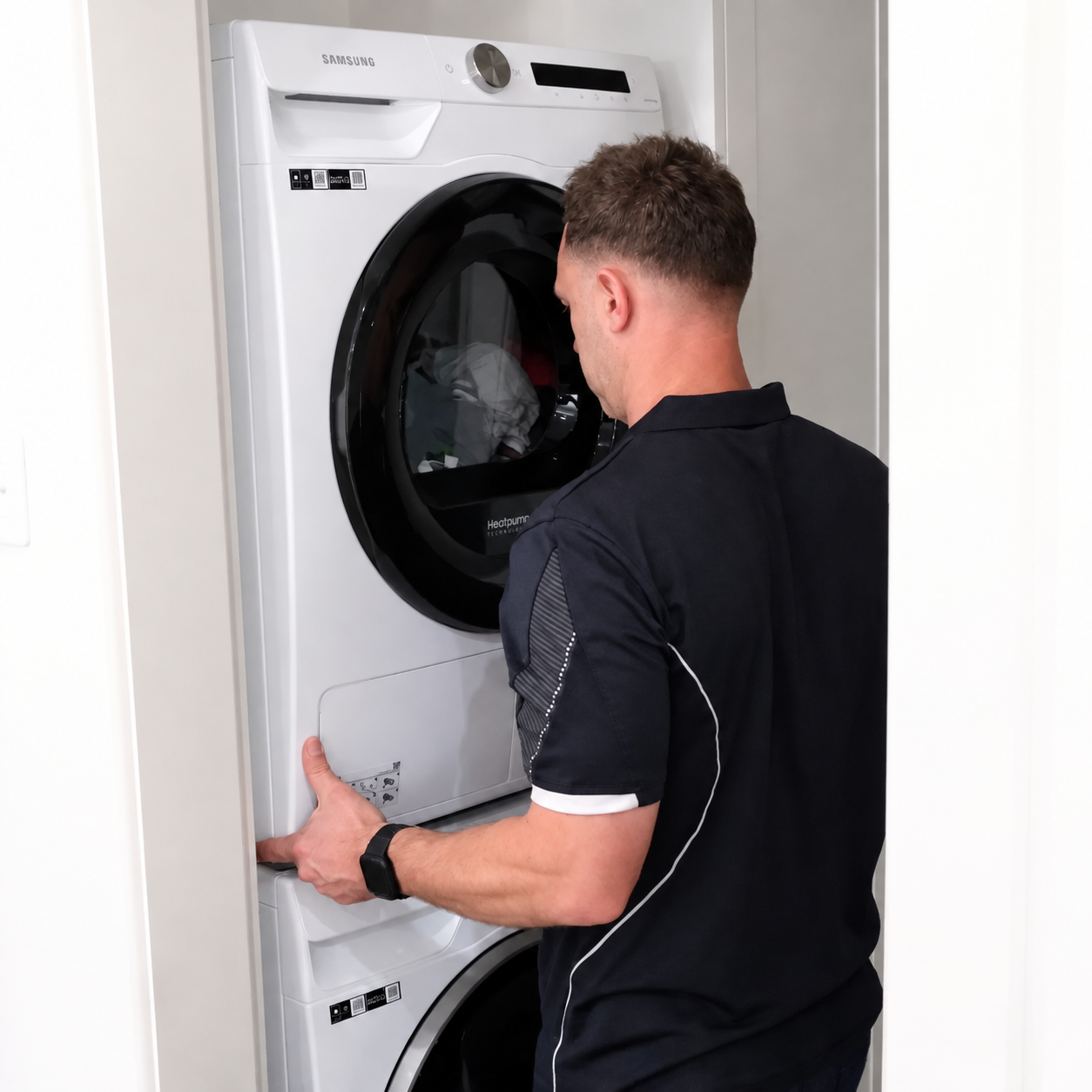 Plumber installing a stacked washing machine and dryer